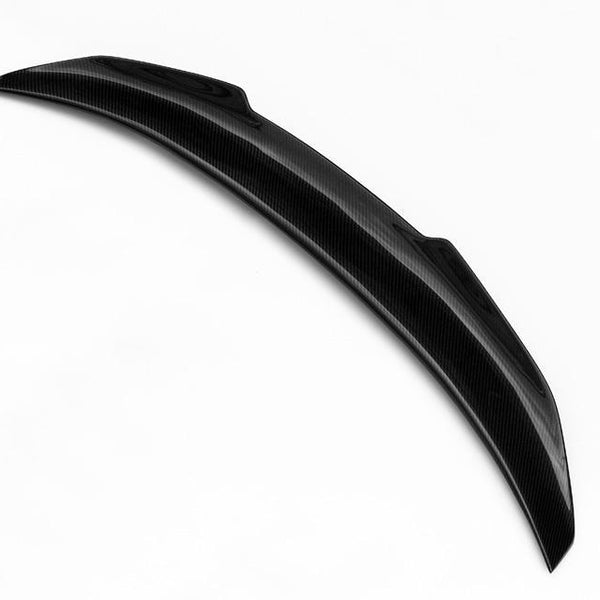 A curved black car spoiler rests on a plain white background, showcasing its sleek carbon fiber texture and aerodynamic design.