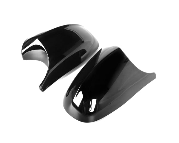 Two glossy black plastic covers lay side by side, displaying curved, aerodynamic designs, against a plain white background.