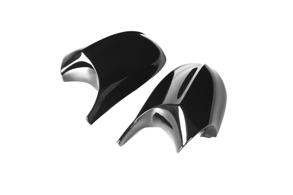 Two glossy, black side view mirror covers for a vehicle are placed on a plain white background, showcasing their sleek, aerodynamic design.