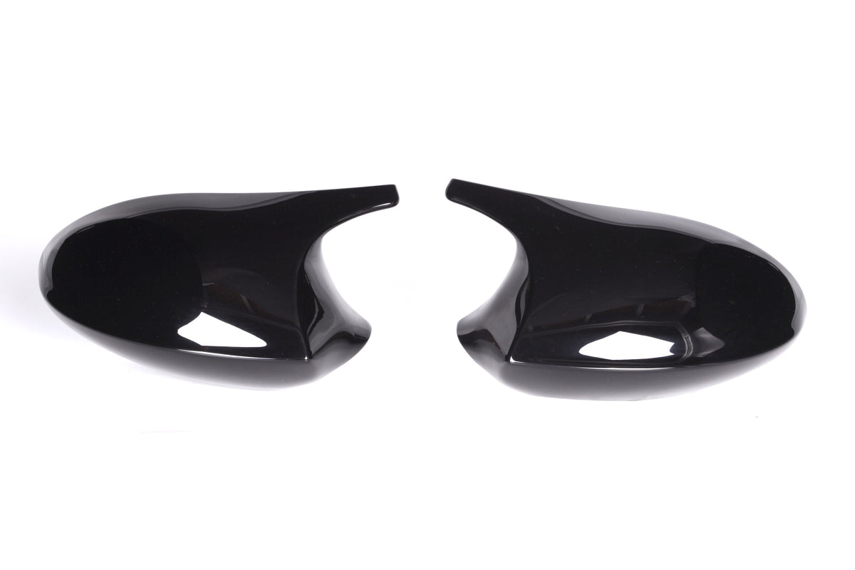 Two glossy black side mirror covers facing each other on a white background, with a sleek, curved design.
