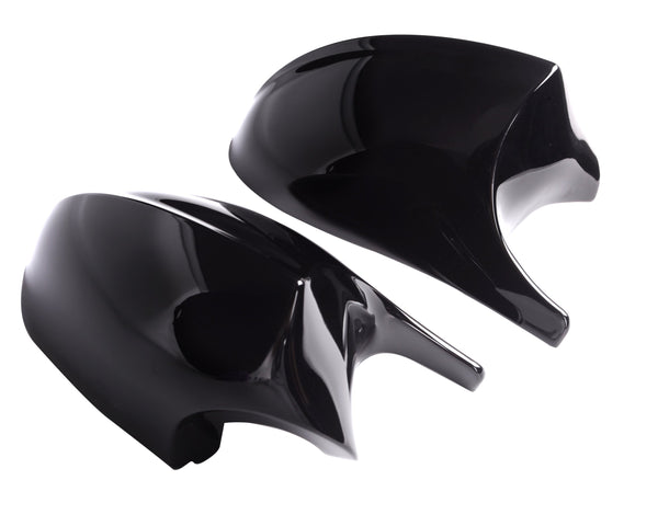 Two shiny black car mirror covers rest side by side against a plain white background, reflecting light on their smooth surfaces.