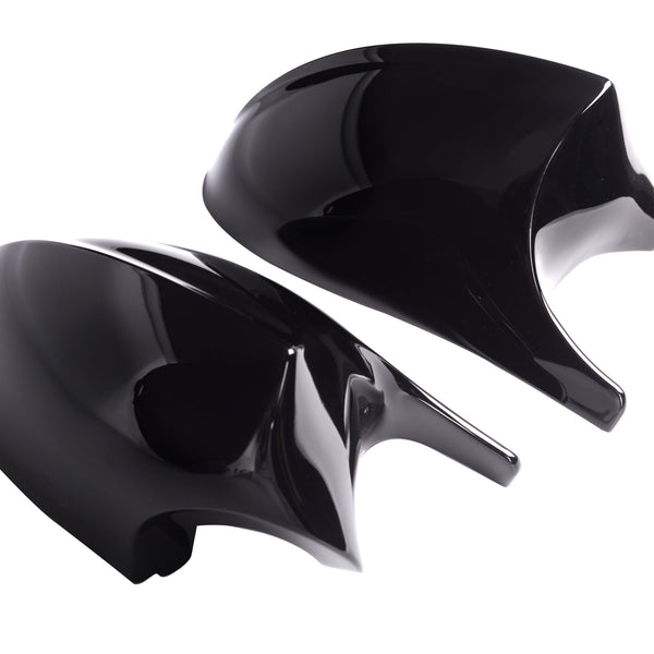 Two sleek, glossy black car mirror covers rest on a white background, reflecting light. The aerodynamic design suggests a modern vehicle accessory, with each piece symmetrical and curved.