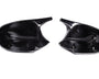 Two black plastic car mirror covers lie side by side, displaying attachment clips inside. They rest on a plain white background, illustrating their smooth, reflective surfaces and curved shapes.