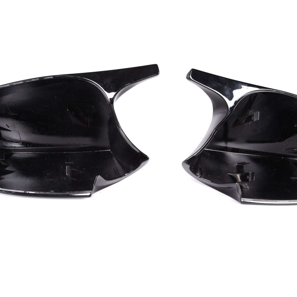 Two black plastic car mirror covers, facing upward, positioned side by side on a plain white background.
