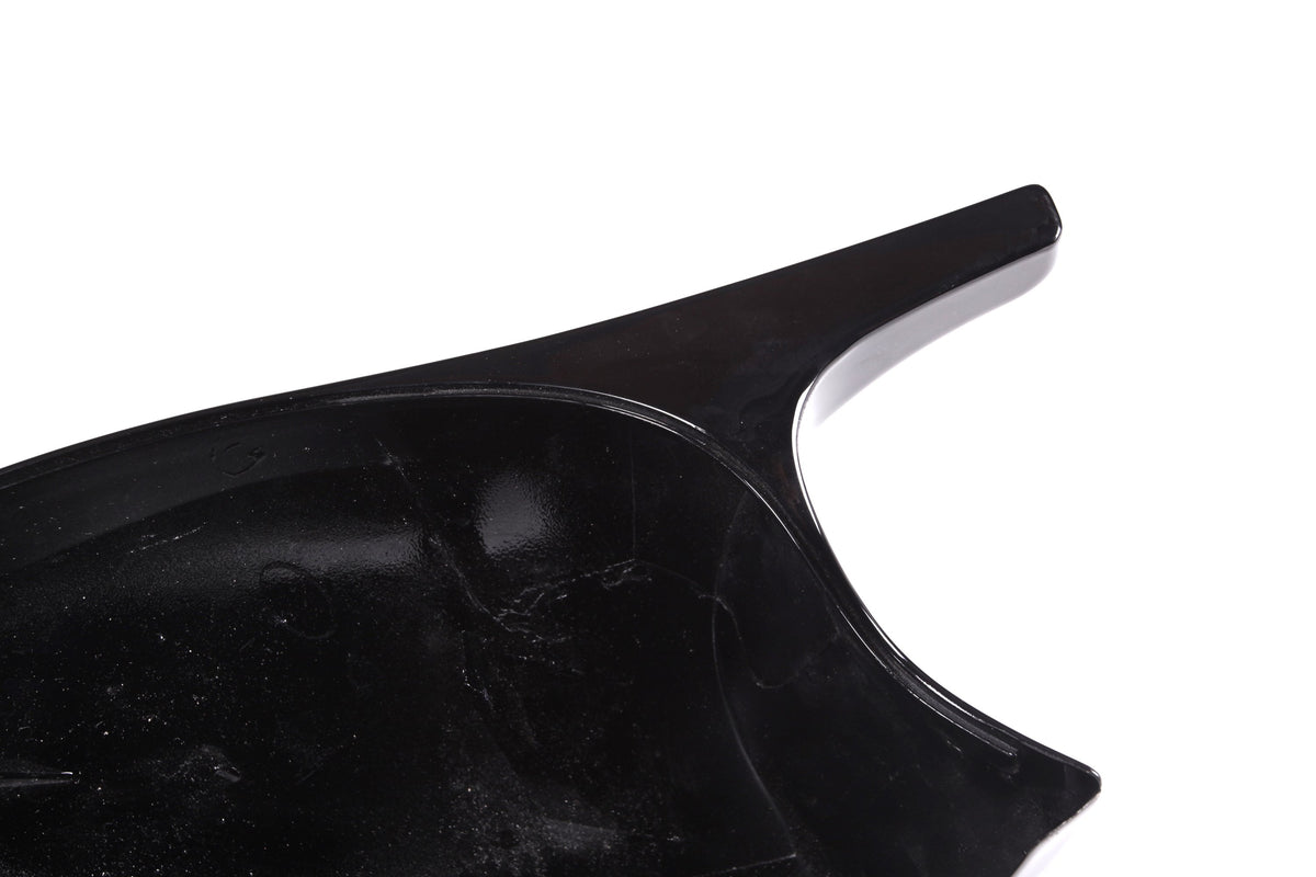 A glossy, black plastic object with a curved surface and a protruding handle, set against a white background.