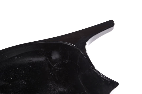 A glossy, black plastic object with a curved surface and a protruding handle, set against a white background.