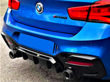 The image shows the rear of a blue BMW car with dual exhausts, parked on asphalt. The badge reads 