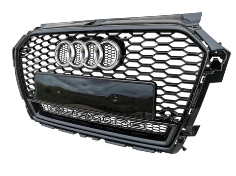 A black hexagonal car grille featuring the Audi logo and the word "quattro" at the bottom, displayed against a plain white background.